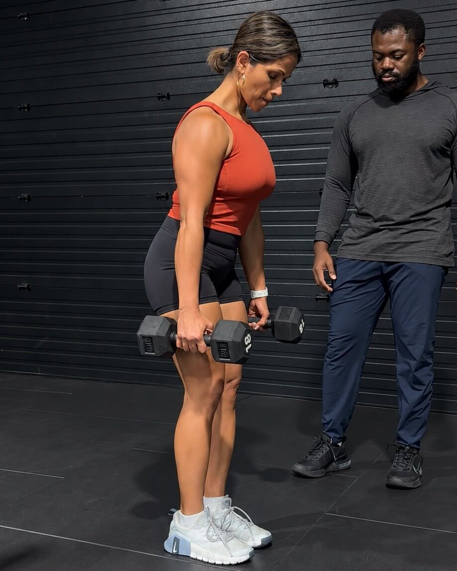 Doug watching a client hold a dumbbell lift.